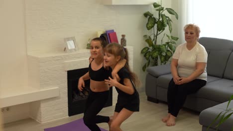 Two-happy-little-girls-are-dancing-and-smiling-while-playing-in-children's-room-at-home