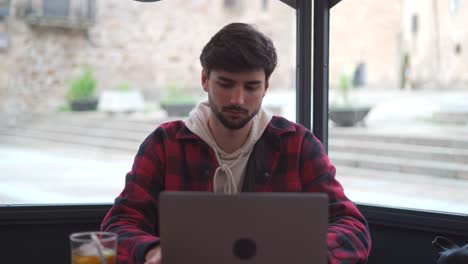 Hombre-Bebiendo-Un-Refresco-Mientras-Escribe-En-Una-Computadora-Portátil