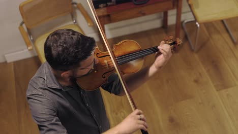 Adult-bearded-luthier-playing-hand-crafted-violin