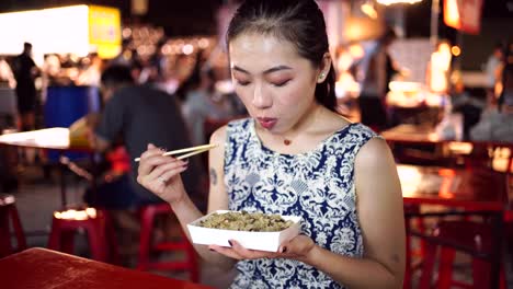 Mujer-Asiática-Comiendo-Arroz-En-El-Mercado-Nocturno