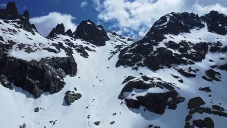 Menschen,-Die-Den-Felsigen-Hang-Eines-Schneebedeckten-Berges-Hinunterfahren