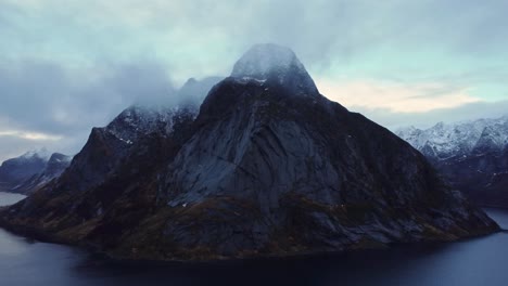 Rocky-mountain-ridge-and-wavy-sea-against-gloomy-sky-in-Norway