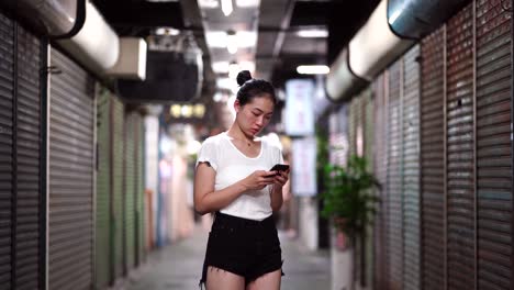 Ethnic-woman-with-smartphone-walking-on-underground-passage