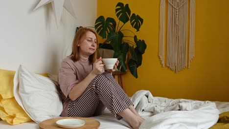 Woman-drinking-coffee-in-bedroom