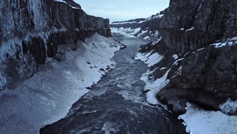River-flowing-between-frozen-cliffs