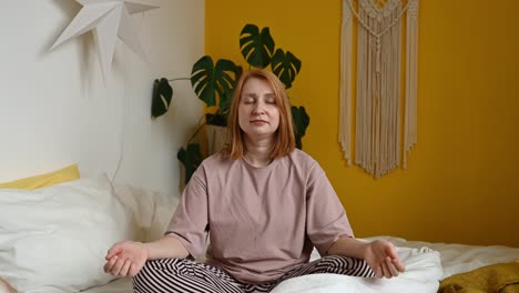 Frau-Sitzt-Auf-Dem-Bett-Und-Meditiert-Mit-Geschlossenen-Augen-Im-Lotussitz
