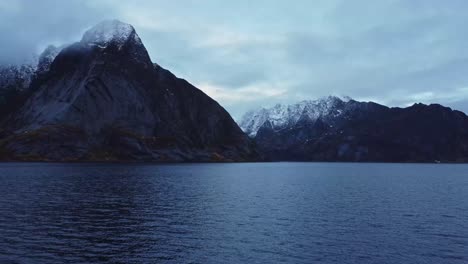 Rocky-mountain-ridge-and-wavy-sea-against-gloomy-sky-in-Norway