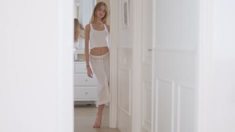 Young-alluring-lady-walking-in-hall-of-apartment