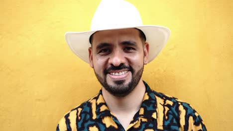 Hispanic-man-in-hat-near-yellow-wall