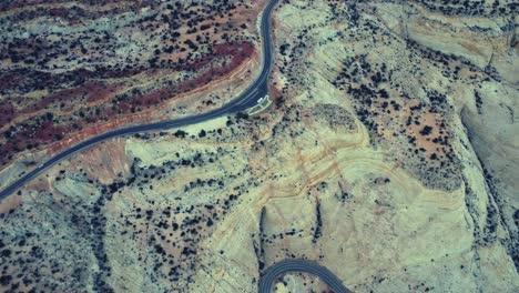 Drone-view-of-asphalt-road-going-through-sandy-valley-in-Utah