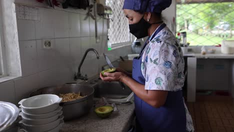 Chef-Femenina-étnica-Con-Aguacates-Cortados-En-La-Cocina