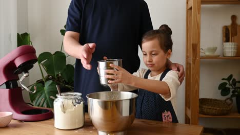 Father-And-Daughter-Sifting-Flour-Into-Mixing-Bowl