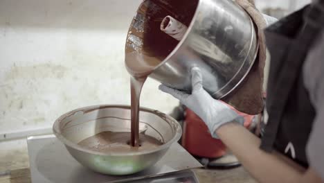 Crop-woman-pouring-melted-chocolate-into-scale-bowl