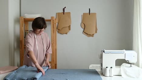 Seamstress-rolling-up-fabric-in-workshop