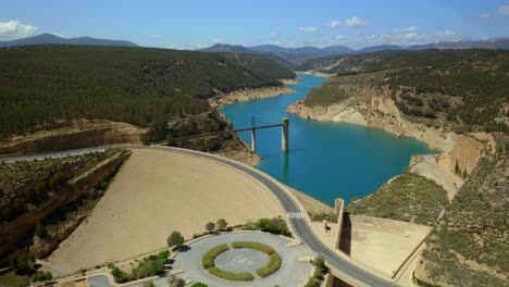 Drone-view-of-dam-with-road-closing-reservoir