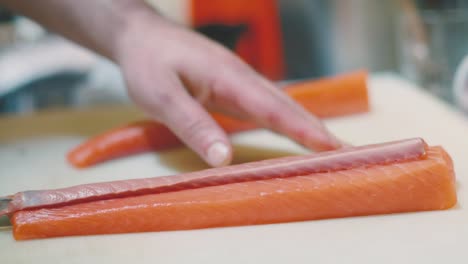 Unrecognizable-cook-cutting-raw-salmon