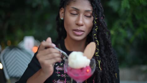 Afro-latina-woman-eating-ice-cream-in-restaurant