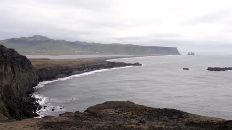 Rocky-cliff-washed-by-foamy-sea-in-overcast-weather