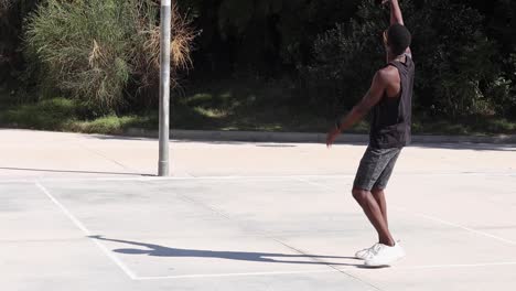 Hombre-Negro-Jugando-Baloncesto-En-El-Campo-De-Deportes