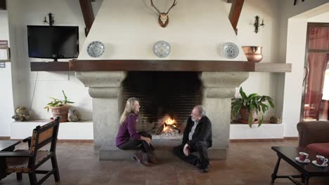 Senior-couple-resting-near-fireplace