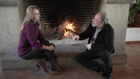 Senior-couple-resting-near-fireplace