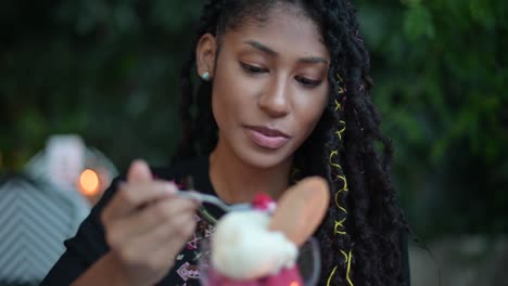 Afro-latina-woman-eating-ice-cream-in-restaurant