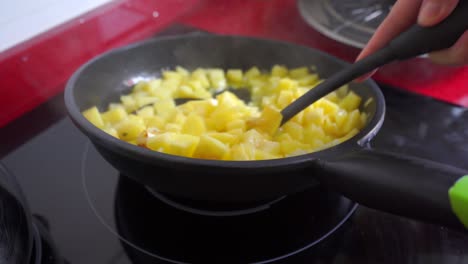 Stirring-the-onion-and-potatoes-in-a-frying-pan