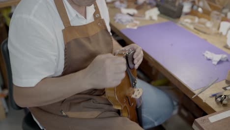 Craftsman-with-violin-in-professional-workshopcro