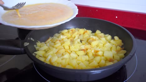 Geschlagenes-Ei-Mit-Kartoffeln-Und-Zwiebeln-In-Die-Pfanne-Geben