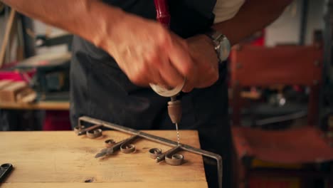 Carpenter-drilling-wooden-detail-at-workbench