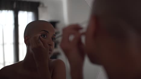 Serious-black-woman-doing-makeup-at-home