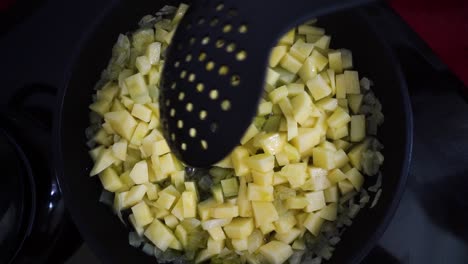 Zwiebeln-Und-Kartoffeln-In-Einer-Bratpfanne-Verrühren