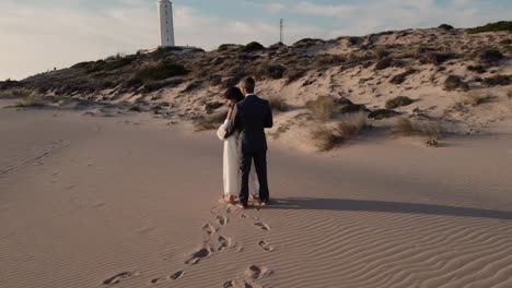 Loving-bride-and-groom-enjoying-romantic-moment-on-sandy-shore