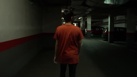 Man-walking-inside-a-subterranean-parking-garage