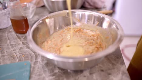 Crop-cook-adding-ingredients-in-bowl-with-batter