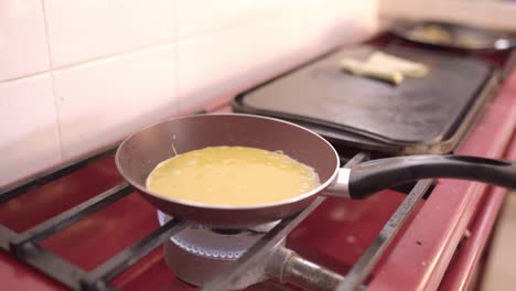 Crop-cook-preparing-omelette-on-pan