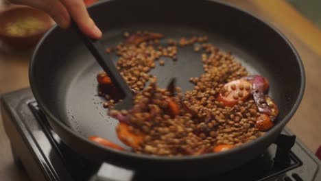 Crop-cook-frying-vegetables-with-lentils