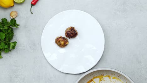 Woman-serving-meatballs-on-ceramic-plate