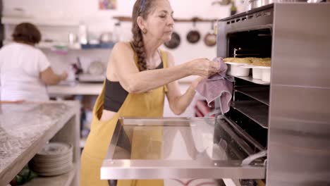 Mexican-woman-baking-dessert-in-oven-at-home