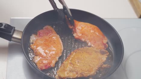 Unrecognizable-cook-frying-tenderloin-marinated-in-pan
