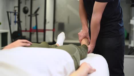 Crop-therapist-massaging-foot-of-patient-in-clinic