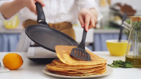 Anonymous-cook-putting-a-pancake-on-top-of-another-pancake