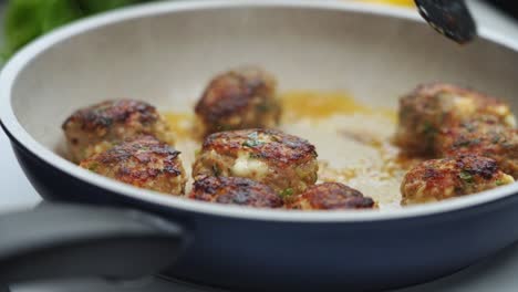 Unrecognizable-person-cooking-meatballs-on-frying-pan-with-oil