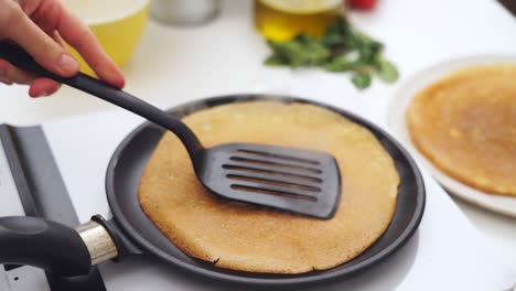 Anonymous-person-flipping-a-pancake-in-the-frying-pan