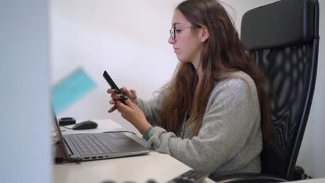 Woman-working-on-computer-and-having-phone-call