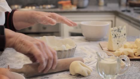 Crop-cook-preparing-crust-for-quiche-in-kitchen-at-home
