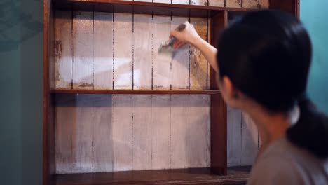 Mujer-Asiática-Pintando-Estantes-De-Madera-En-Casa