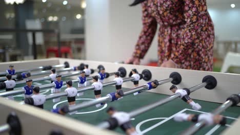 Anonymous-coworkers-playing-foosball-during-break