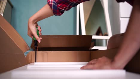 Crop-woman-assembling-furniture-alone-at-home