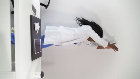 Black-female-doctor-in-medical-uniform-dancing-in-clinic